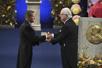 Ceremonial setting: Ferenc Krausz receives the Nobel medal and certificate from the Swedish king Carl Gustaf.