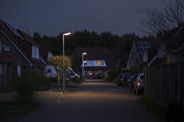 Housing estate at dusk with street lighting